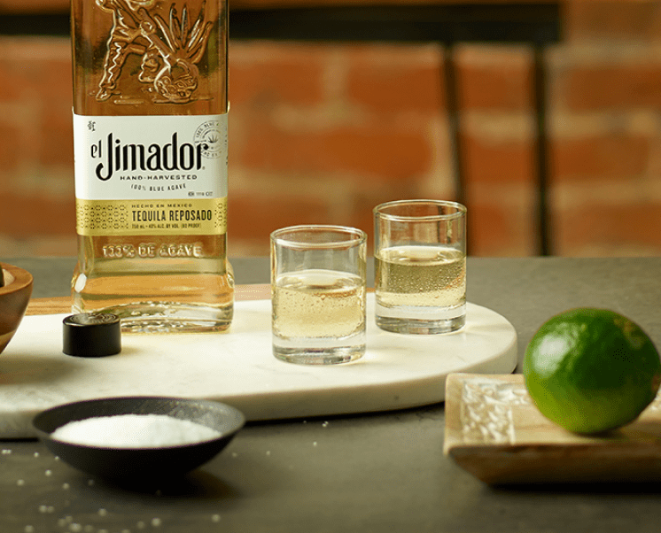 el Jimador Reposado in two shot glasses with lime a lime, salt and el Jimador Reposado bottle.