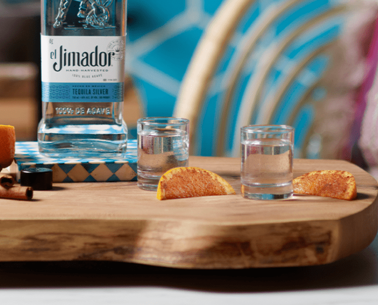 el Jimador Shake and Bite cocktails on a table cinnamon dusted orange slices and el Jimador Silver bottle.