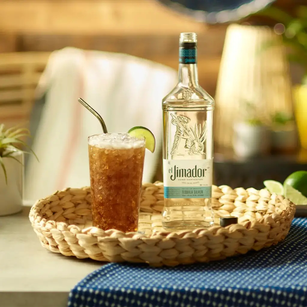 An image of a cocktial on a small round tray with a bottle of el Jimador Silver tequila