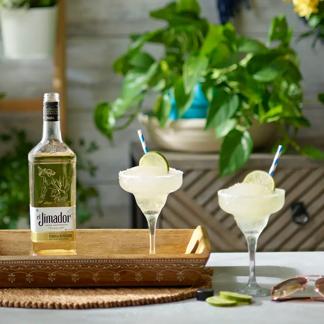 An image of two margaritas on a tray with a bottle of el Jimador Reposado tequila
