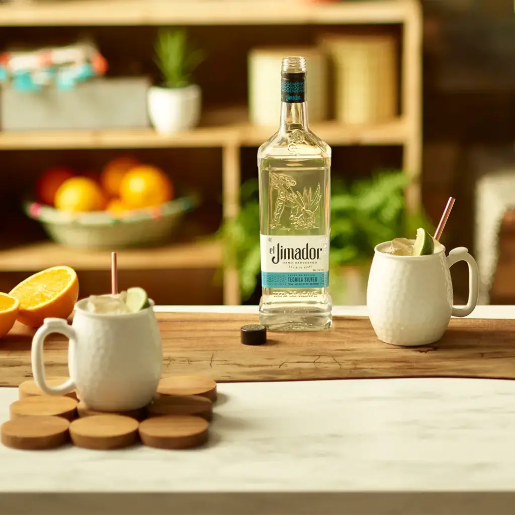 An image of two mule cocktails on a counter with a bottle of el Jimador Silver tequila