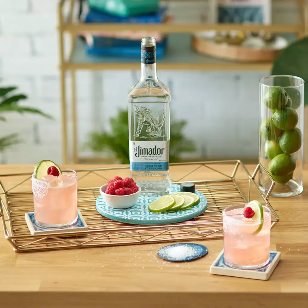 An image of two cocktails on a counter with a bottle of el Jimador Silver tequila